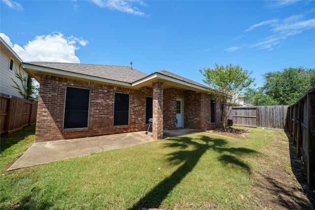 rear view of property featuring a patio area and a yard