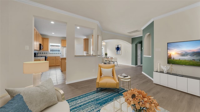 living room with ornamental molding and light hardwood / wood-style floors