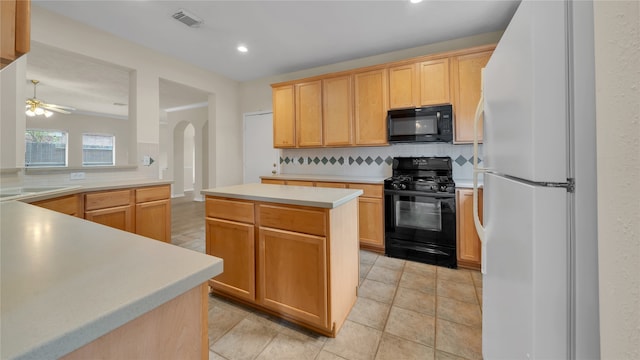 kitchen featuring black appliances, light brown cabinetry, tasteful backsplash, a center island, and ceiling fan