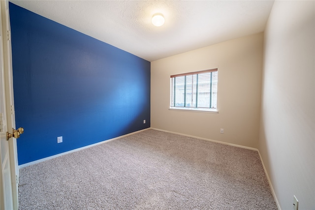 empty room with a textured ceiling and carpet floors