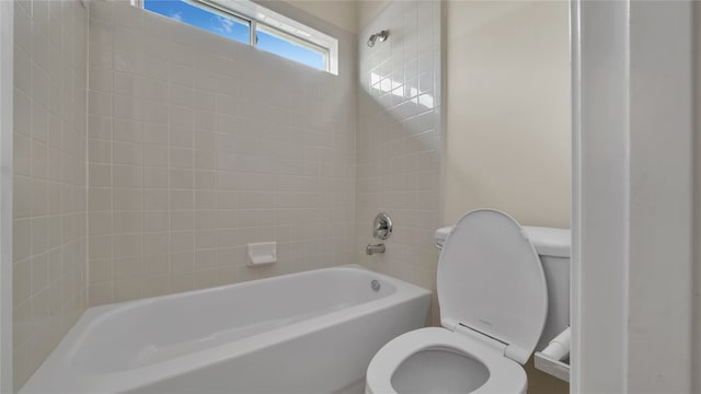 bathroom with toilet and tiled shower / bath