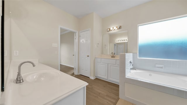 bathroom featuring vanity, hardwood / wood-style flooring, and tiled bath