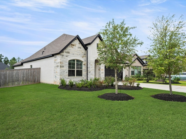 french country inspired facade with a front yard