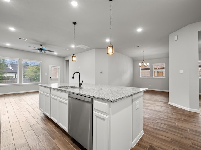 kitchen with dishwasher, sink, ceiling fan with notable chandelier, white cabinetry, and a center island with sink