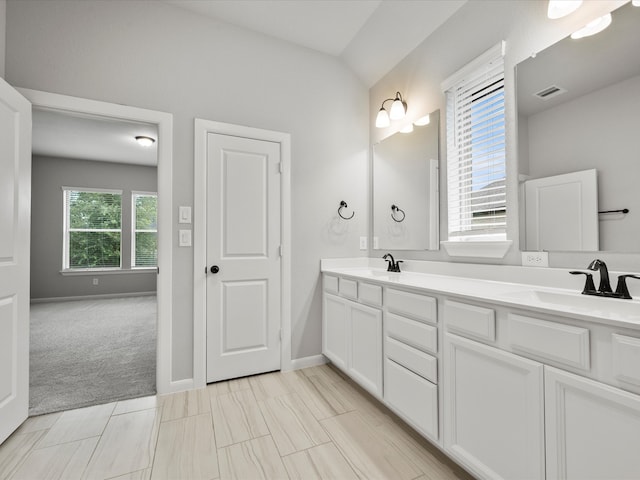 bathroom featuring lofted ceiling and vanity