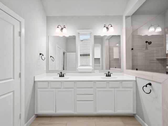 bathroom featuring a tile shower and vanity