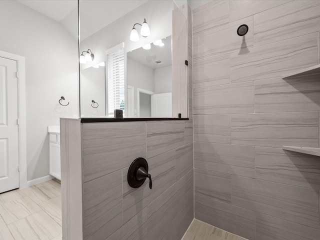 bathroom with vanity and tiled shower