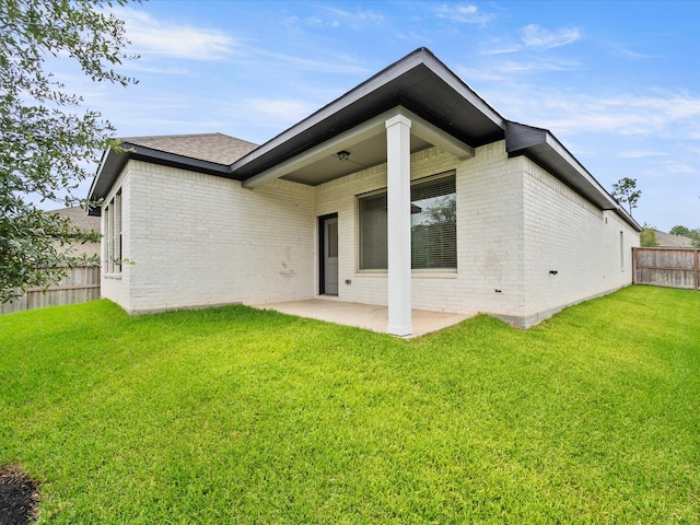 back of house with a patio and a yard