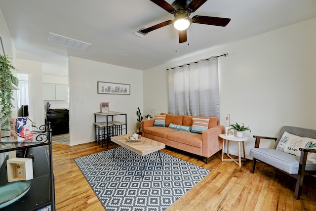 living room featuring ceiling fan, light hardwood / wood-style floors, and a healthy amount of sunlight