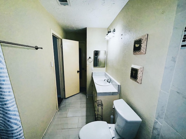 bathroom with tile patterned floors, toilet, and vanity