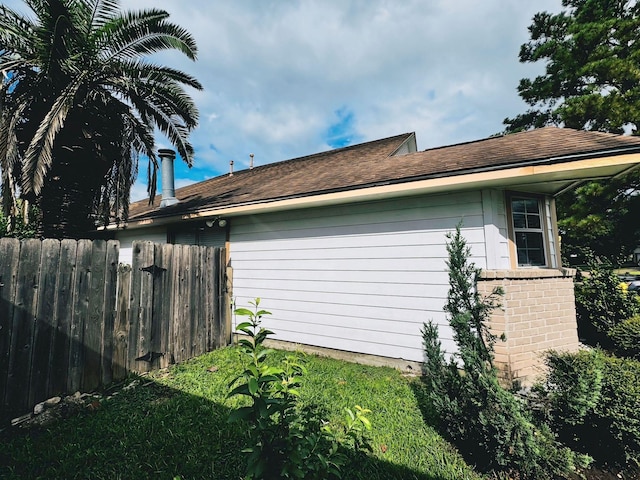 view of property exterior with brick siding and fence