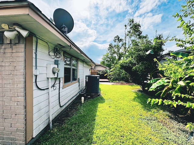 view of yard with central AC unit and fence