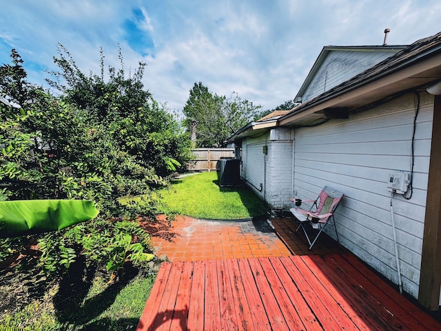 wooden terrace featuring a lawn and a patio