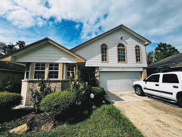 tri-level home featuring brick siding, an attached garage, and driveway