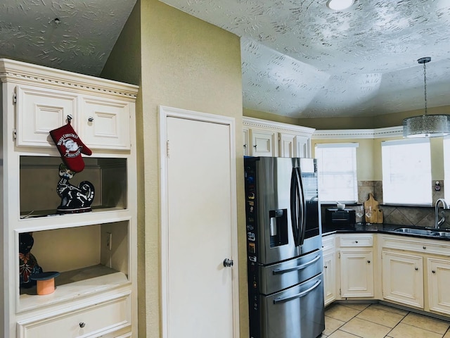 kitchen featuring light tile patterned floors, sink, hanging light fixtures, stainless steel refrigerator with ice dispenser, and vaulted ceiling