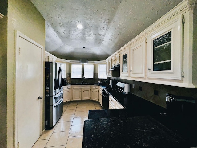 kitchen featuring black stove, stainless steel fridge, sink, hanging light fixtures, and light tile patterned flooring