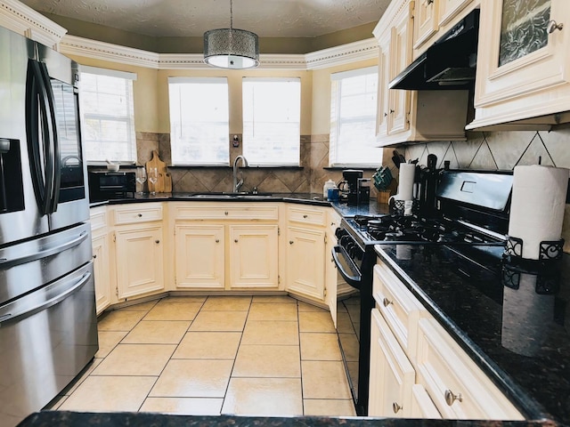 kitchen with black gas range oven, stainless steel fridge with ice dispenser, under cabinet range hood, light tile patterned flooring, and a sink