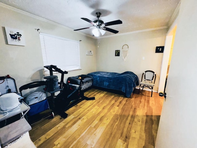 bedroom with ornamental molding, hardwood / wood-style floors, and ceiling fan