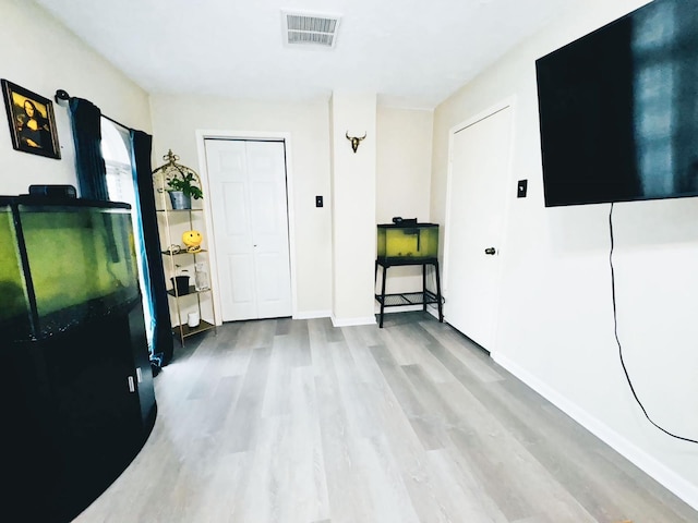 foyer featuring visible vents, baseboards, and wood finished floors