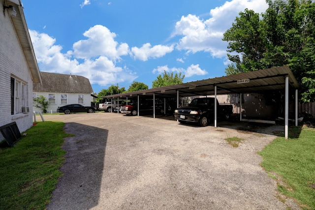 view of car parking featuring a yard and a carport