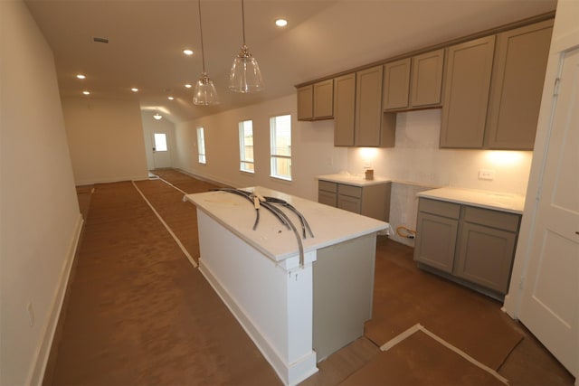 kitchen with hanging light fixtures, a kitchen island with sink, and gray cabinetry