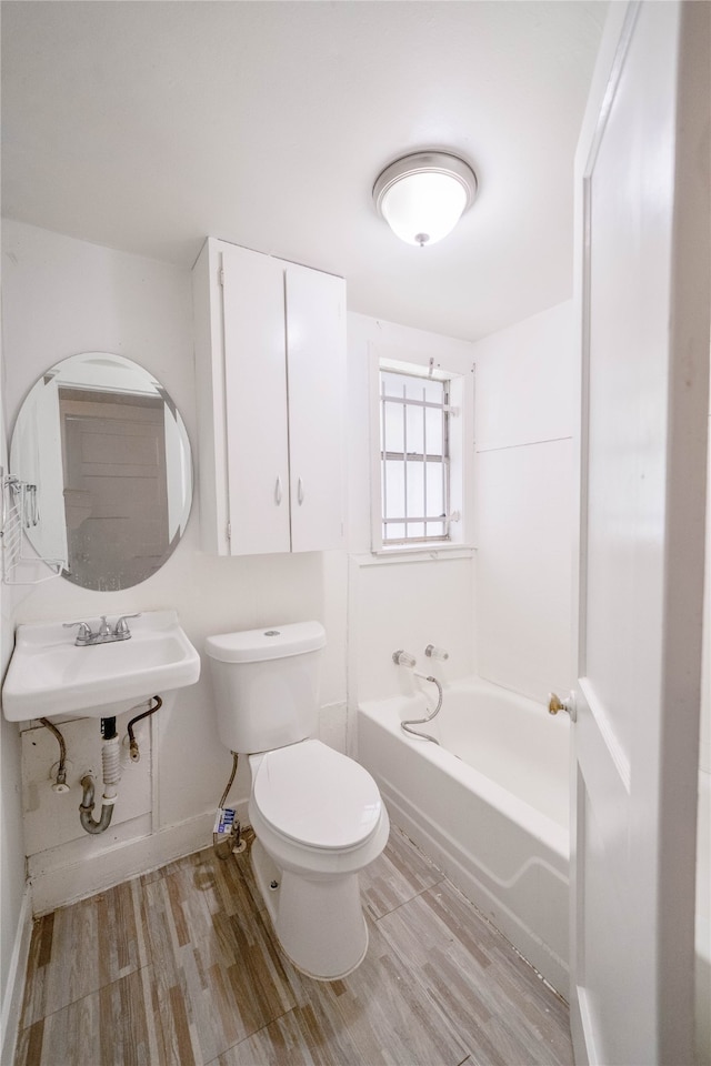 bathroom featuring toilet, hardwood / wood-style floors, and sink