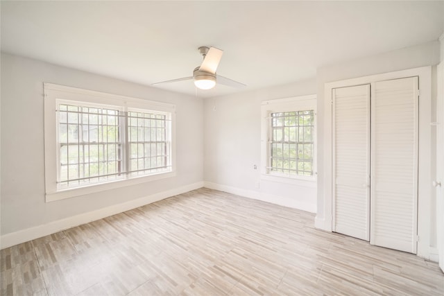 unfurnished bedroom with ceiling fan, a closet, and light wood-type flooring