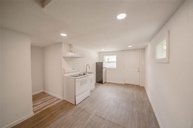 kitchen featuring white cabinets, white range with electric stovetop, light hardwood / wood-style floors, and stainless steel refrigerator