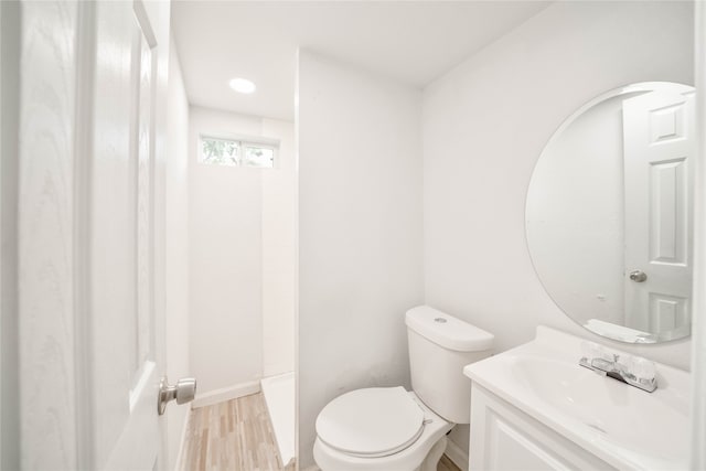 bathroom with vanity, toilet, a shower, and hardwood / wood-style flooring