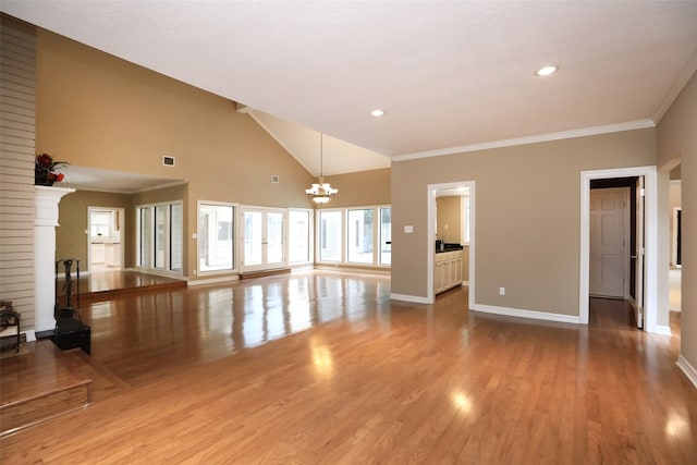 unfurnished living room featuring light wood-type flooring, high vaulted ceiling, a notable chandelier, and ornamental molding