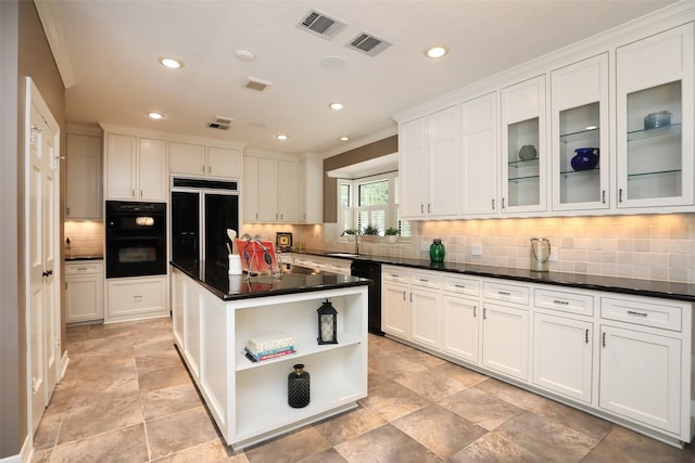 kitchen with crown molding, a center island, white cabinets, and black appliances