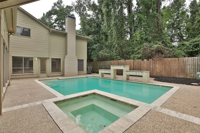 view of pool featuring a patio and an in ground hot tub