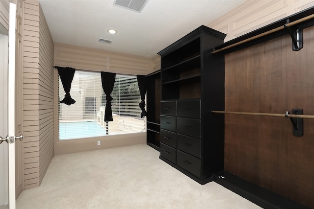 walk in closet featuring light colored carpet