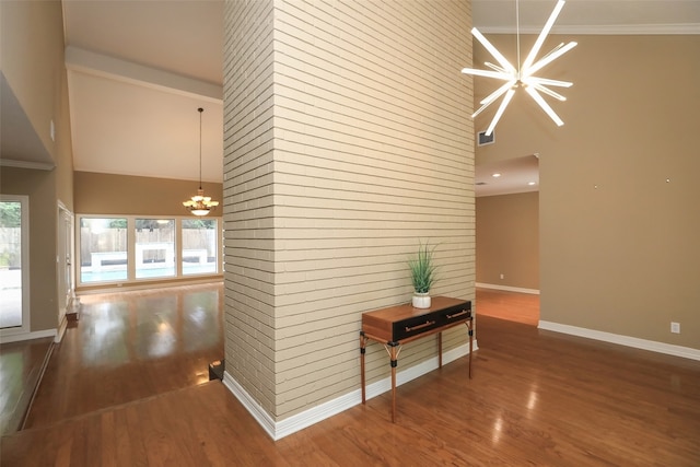 hallway featuring high vaulted ceiling, wood-type flooring, and an inviting chandelier