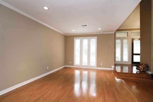 empty room featuring crown molding and hardwood / wood-style flooring