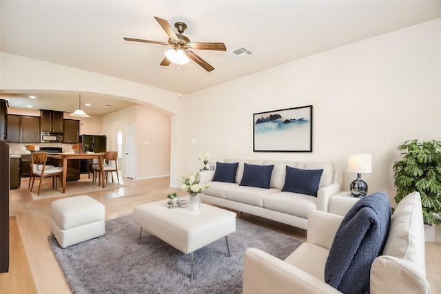 living room with ceiling fan and light wood-type flooring