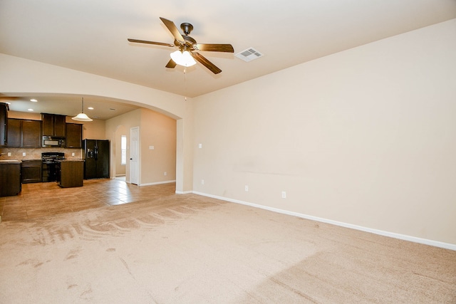 unfurnished living room featuring light carpet, sink, and ceiling fan