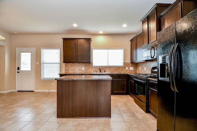 kitchen with black appliances, a healthy amount of sunlight, sink, and a kitchen island