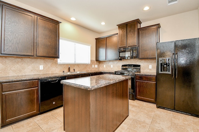 kitchen featuring black appliances, backsplash, stone counters, and a kitchen island