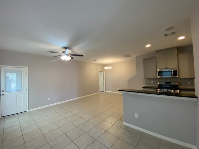 kitchen with tasteful backsplash, gray cabinetry, ceiling fan with notable chandelier, stainless steel appliances, and light tile patterned floors