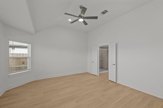 spare room featuring lofted ceiling, light wood finished floors, visible vents, and baseboards