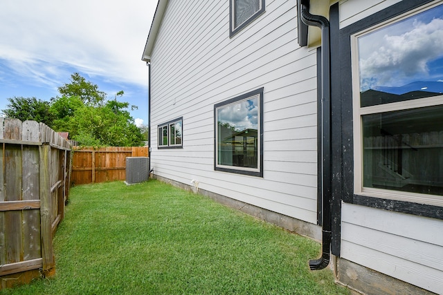 view of home's exterior featuring a lawn and central AC