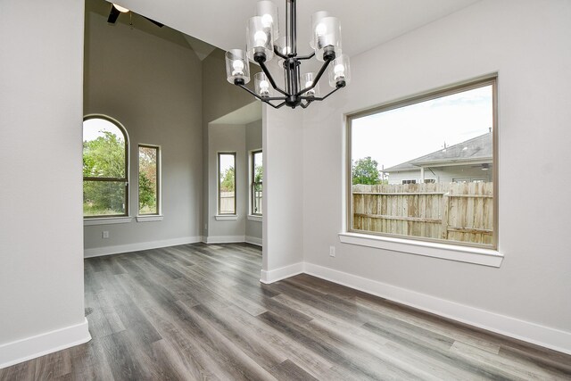 interior space with lofted ceiling, an inviting chandelier, and hardwood / wood-style flooring