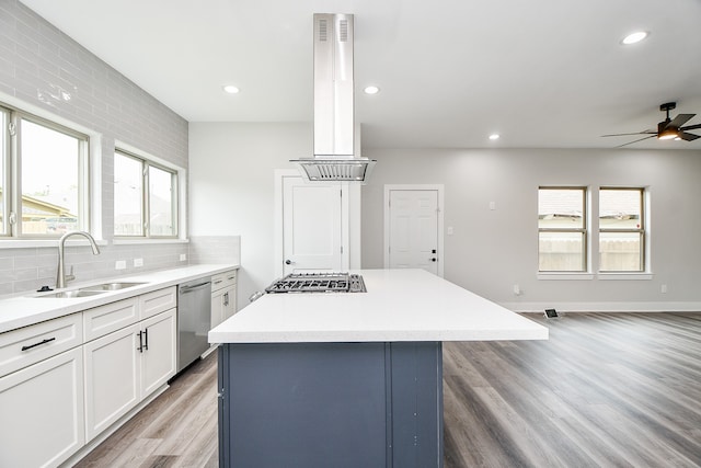 kitchen featuring appliances with stainless steel finishes, plenty of natural light, sink, ceiling fan, and a kitchen island