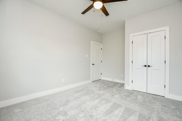 unfurnished bedroom featuring a closet, ceiling fan, and light colored carpet