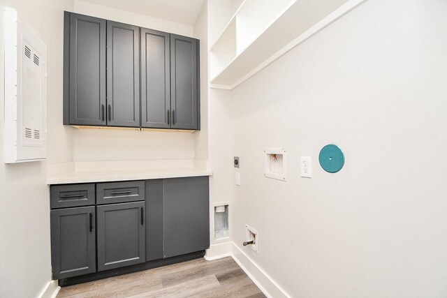 laundry area featuring cabinets, light hardwood / wood-style floors, washer hookup, hookup for an electric dryer, and hookup for a gas dryer