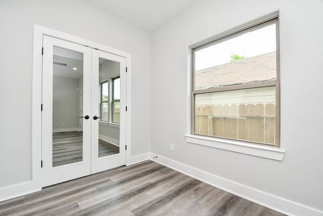 unfurnished room featuring a wealth of natural light, hardwood / wood-style flooring, and french doors