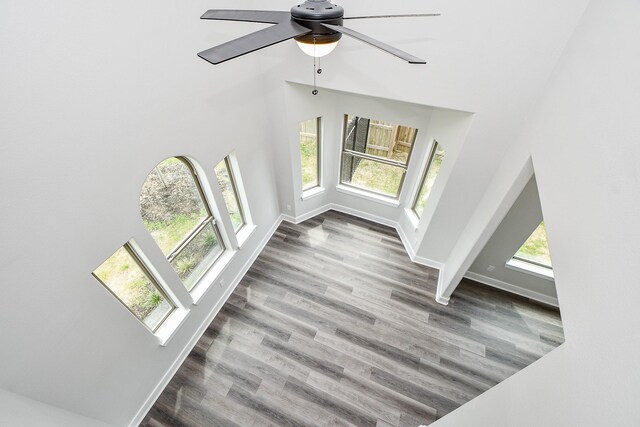 unfurnished living room with ceiling fan, hardwood / wood-style flooring, and plenty of natural light