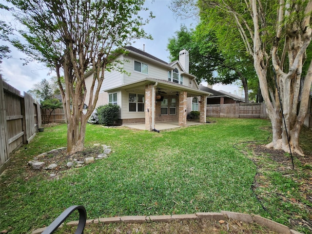 back of property with a yard and a patio area