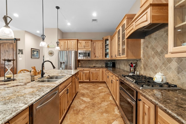 kitchen featuring sink, stainless steel appliances, tasteful backsplash, light stone counters, and decorative light fixtures